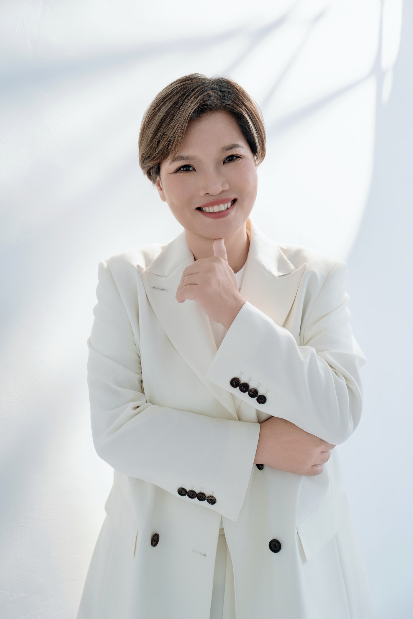 四十歲之後的專業形象照：資深女性經營者篤定的神情與合身的白色西裝套裝